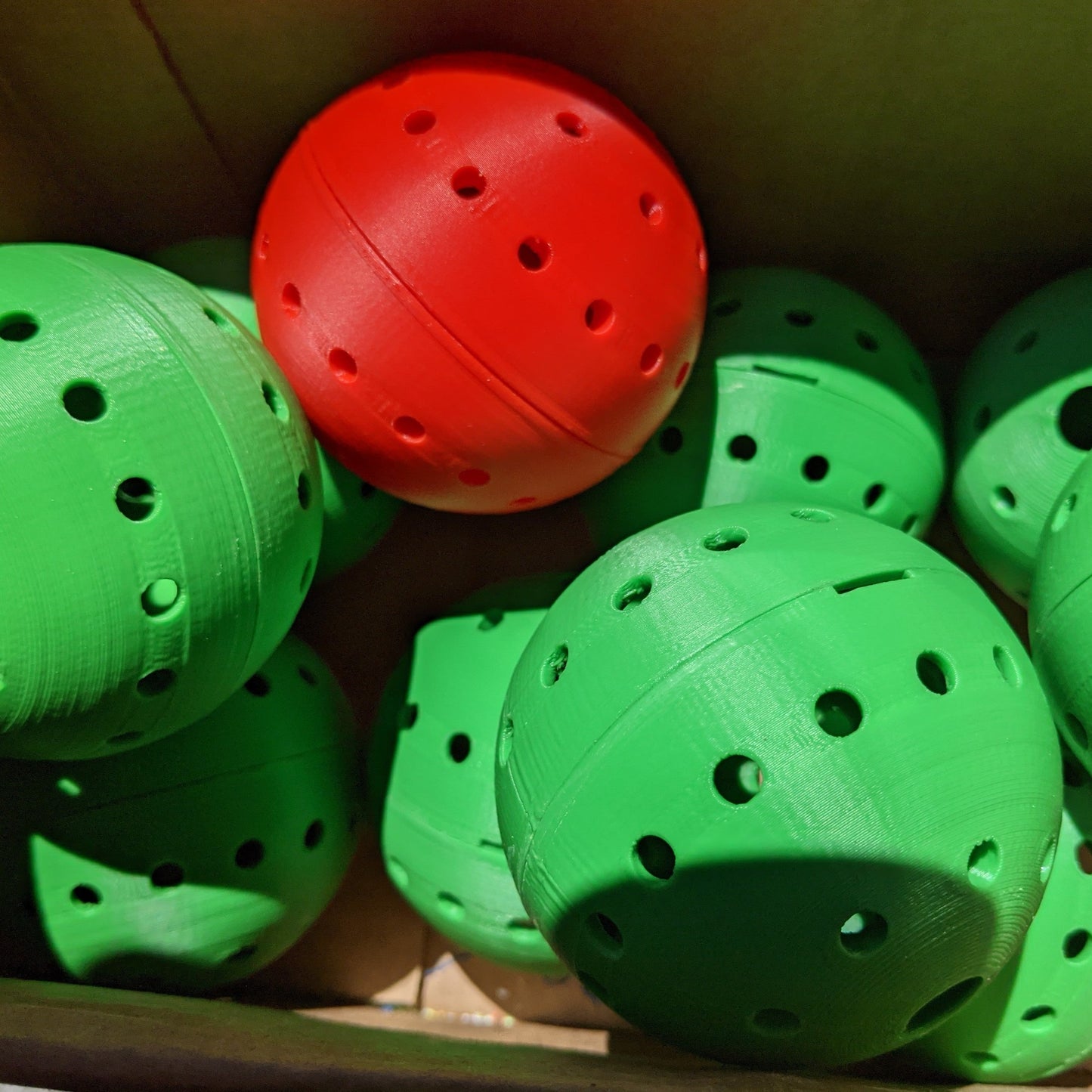 Plastic Green and red balls with holes for treats to fall out